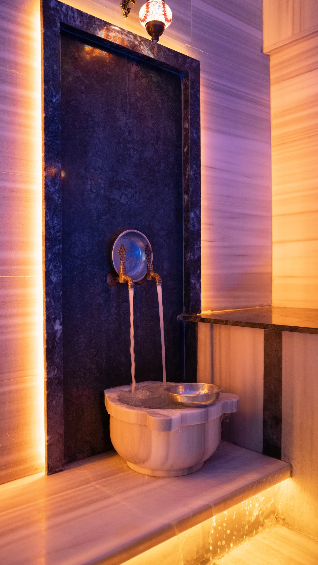 Private Spa Anatolia hamam alanında aydınlatılmış çeşme ve kurna